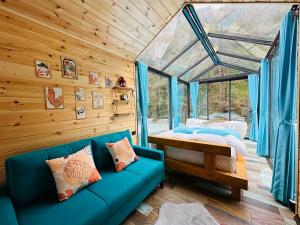 艾德亚耶拉西River Land Rize的客厅配有蓝色的沙发和床。