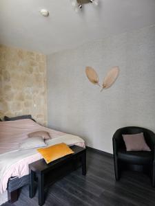 B&B Soissons L'Arthome chambres d'hôtes的一间卧室配有一张床和一张黑椅