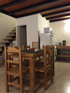 乌斯怀亚武库公寓的厨房配有木桌、椅子和冰箱
