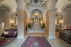 帕尔马Grand Hotel di Parma的大堂设有楼梯和吊灯