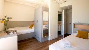 佛罗伦萨Il Santo Stays的一间小卧室,配有两张床和镜子