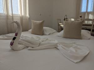 凯法洛斯Cute apartments的一张白色的床,上面有塞满的天鹅