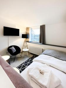 锡根SI-View Einzelzimmer Zimmer 25的卧室配有一张床,墙上配有电视。