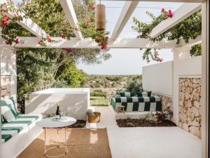休达德亚莫维德拉努乡村酒店的庭院配有绿色和白色的家具和鲜花