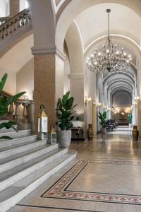 帕尔马Grand Hotel di Parma的一个带楼梯和吊灯的大型大堂