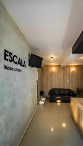 齐克拉约ESCALA BUSINESS HOTEL的一间房间,配有床和墙上的标志