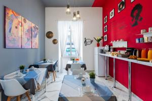 那不勒斯克洛里诺特住宿加早餐旅馆的一间设有两张桌子和红色墙壁的餐厅