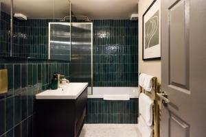 特威克纳姆The Twickenham Wonder - Lovely 1BDR Flat with Parking的绿色瓷砖浴室设有水槽和浴缸