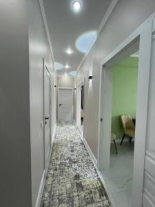阿斯塔纳Нурсултан-сити的一条带白色墙壁的走廊和一条铺有地毯的走廊
