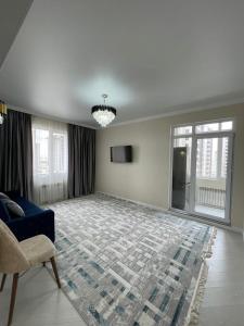 阿斯塔纳Нурсултан-сити的客厅配有蓝色的沙发和地毯。
