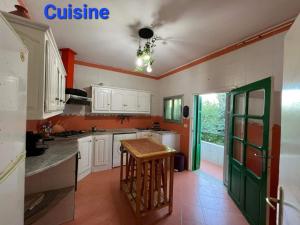 艾因代拉希姆Villa Bel air的厨房配有白色橱柜和绿门