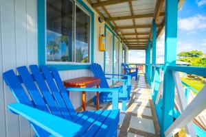 普罗维登西亚Ketlina Village的一个带蓝色椅子和桌子的门廊