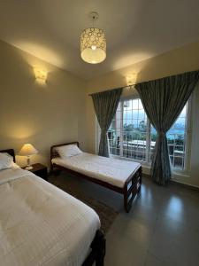 乔奥诺奥尔Sunset Villa的一间卧室设有两张床和大窗户