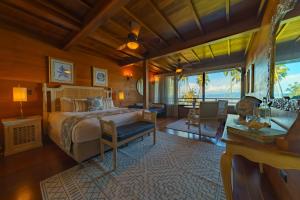 EsquinasPlaya Cativo Lodge的一间卧室设有一张床和一间客厅。
