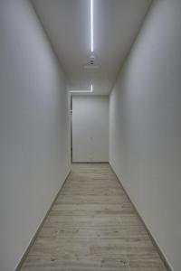 蓬塔阿拉Dimora Punta Ala的走廊设有白色墙壁和木地板