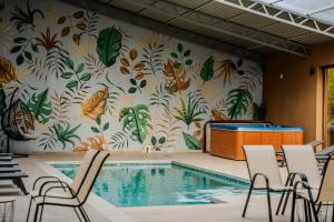 斯雷姆斯卡米特罗维察Plaza La - Night and Spa的墙上挂着蝴蝶壁画的游泳池