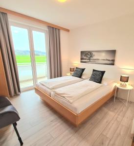 昂特保科洛佩因Ferienpark Scheiber的一间卧室设有一张大床和一个大窗户