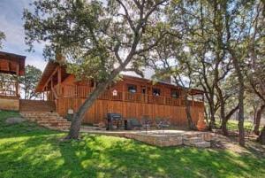 BurnetThunderbird Lodge的一座大木房子,位于一个树木繁茂的院子内