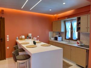 阿菲托斯Cynthia - Christine's House的一个带橙色墙壁和白色大岛的厨房