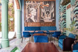 圣玛尔塔卡萨福尔德酒店的一间设有蓝色桌椅和壁画的餐厅