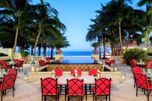 迈阿密海滩Acqualina Resort and Residences的一个带桌椅的庭院和一个游泳池