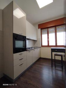 维琴察Appartamento Fiera Vicenza的厨房配有白色橱柜和炉灶烤箱。