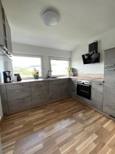 马林诺维德Ferienwohnung TraumZeit的厨房配有不锈钢用具,铺有木地板