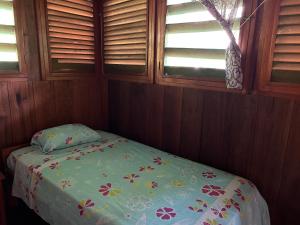 利马Chamisal Jungle Hotel的小卧室配有一张带花卉床罩的床