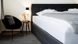 锡根SI-View Doppelzimmer mit Stadtblick Zimmer 20的卧室配有一张白色大床和一把椅子