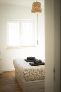 佩尼契Peniche Village Home的白色的客房设有一张带窗户的床