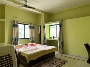 巴特那Amma’s Om stay的一间卧室设有一张床和两个窗户。