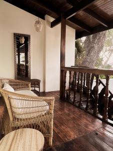 塔马林多Hotel Perla de la Playa的一个带柳条椅的门廊和木地板