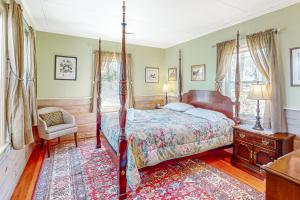 East FalmouthCove Cottage的一间卧室配有一张天蓬床和一把椅子