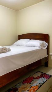 巴克里索莫雷诺港Suite de Asdruval的一间卧室配有一张带白色床单和地毯的床。