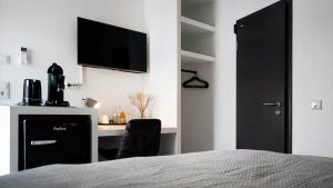 锡根SI-View Doppelzimmer Zimmer 23的一间卧室配有一张桌子和一台墙上的电视。