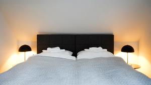锡根SI-View Doppelzimmer Zimmer 23的一张带白色床单和两盏灯的大床