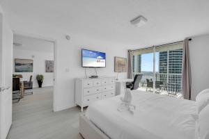 迈阿密Deluxe 1 Bedroom Apartment • Brickell • Ocean View的白色卧室设有一张大床和电视。