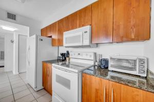 迈阿密Deluxe 1 Bedroom Apartment • Brickell • Ocean View的厨房配有白色家电和木制橱柜