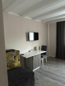 尼什Vila Storia的客房设有书桌、椅子和电视。