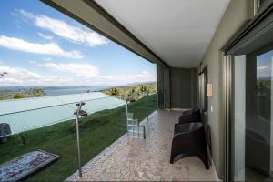 Naranjos AgriosLake Arenal Condos的客房设有一个享有水景的阳台。