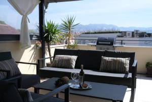 斯普利特Prime Location Penthouse apt with a large terrace的天井配有沙发和带酒杯的桌子