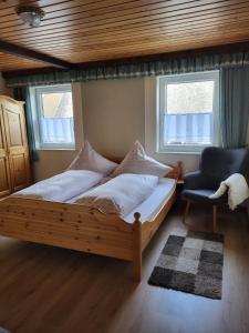 奥古斯都堡Ferienwohnung Augustusburg的一间卧室配有一张木床和一把椅子
