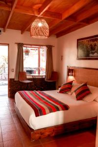 圣佩德罗·德·阿塔卡马Tambo Atacama Lodge的一间卧室配有一张大床和一张桌子