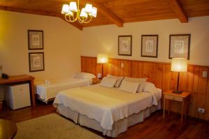 坎波斯杜若尔当Hotel Solar d'Izabel的一间带两张床铺的卧室,位于带木墙的房间内