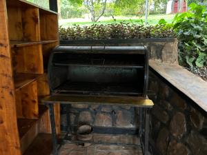MuhaziMuhazi View Resort的砖墙上的室外烧烤架,配有长凳
