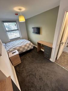 EstonCozy 6 Bedroom HMO的小房间设有一张床和一张书桌