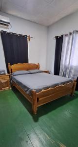 巴斯蒂门多斯Vacaciones en mar y naturaleza的一间卧室设有一张木床,铺有绿色地板。