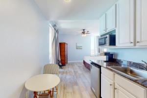 巴拿马城海滩Splash Resort 1901W Suite A Studio的厨房配有白色橱柜、水槽和桌子