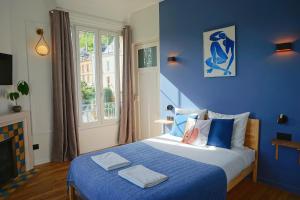拉罗什基永Green Home的蓝色卧室,配有带2条毛巾的床