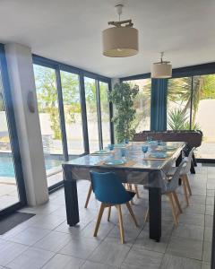SauvianLe havre de paix - Maison familiale avec piscine et climatisation的一间设有大玻璃桌和椅子的用餐室